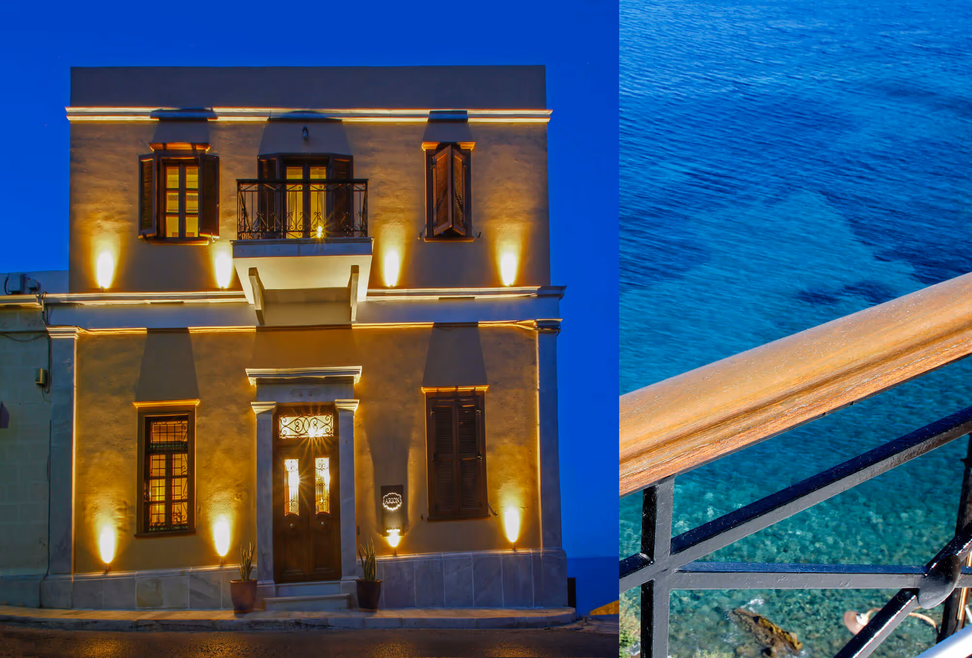 Two-story illuminated building with wooden shutters and balcony at night beside a railing overlooking clear blue water.